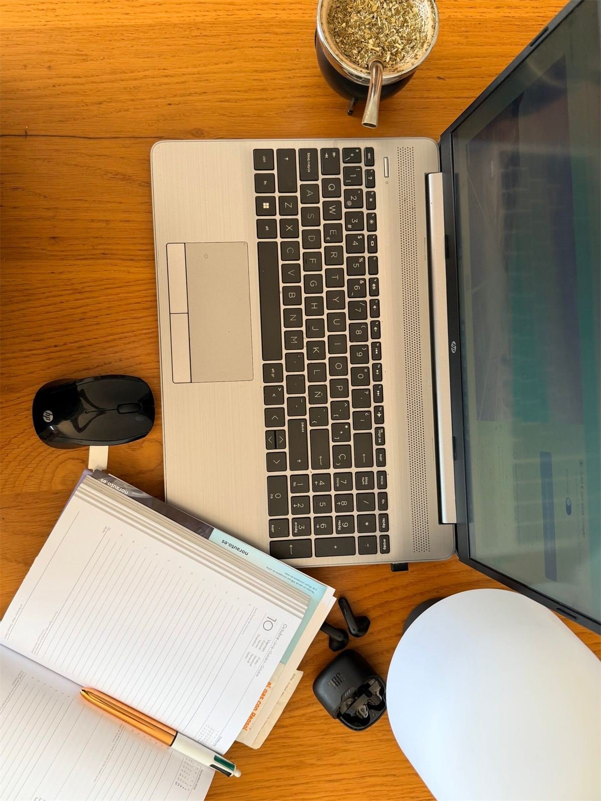 Escritorio de trabajo con notebook, agenda y un mate