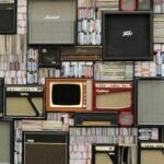 A wall of vintage speakers and TVs surrounded by books and records in a creative display.
